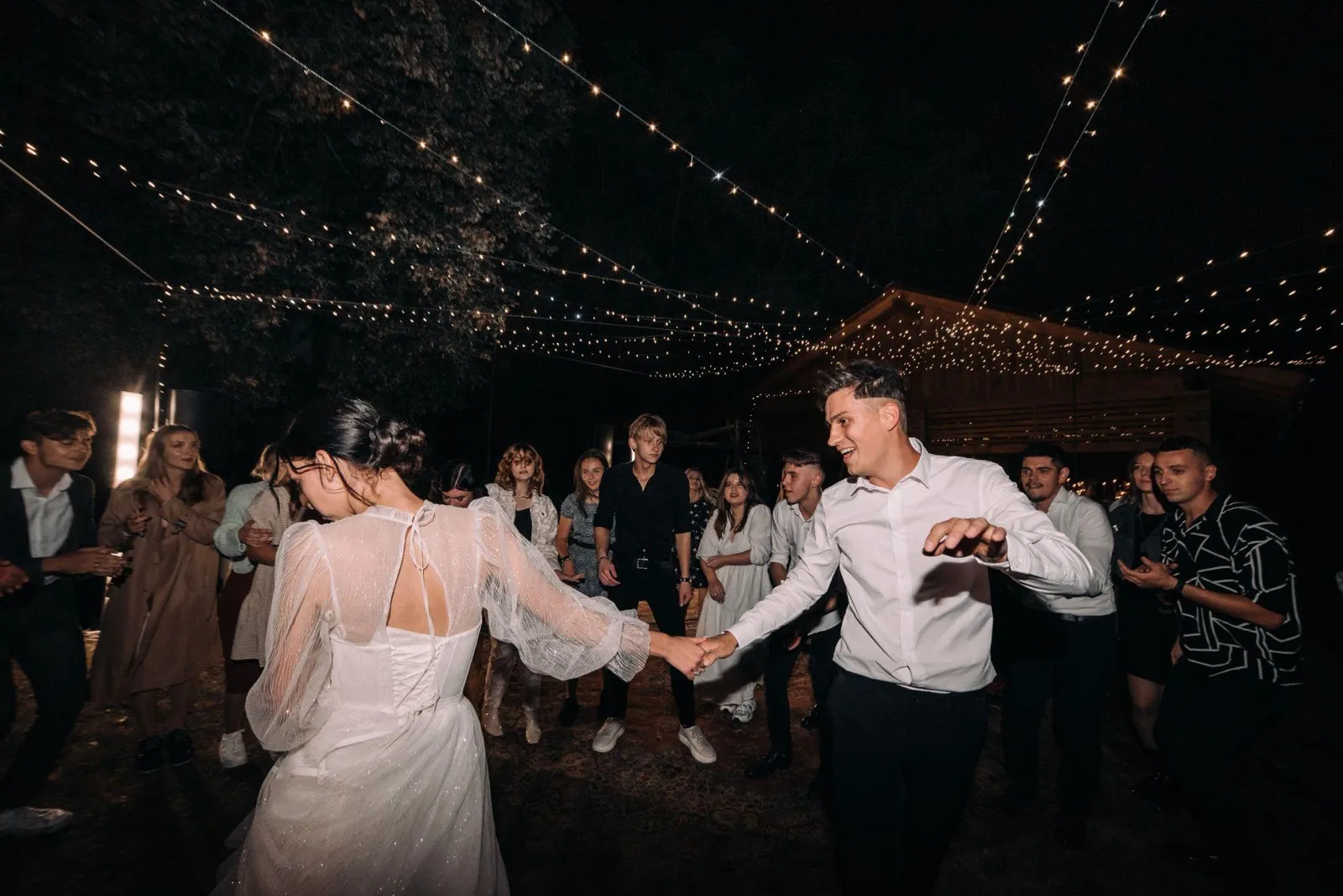 Couple dancing under fairy lights at night