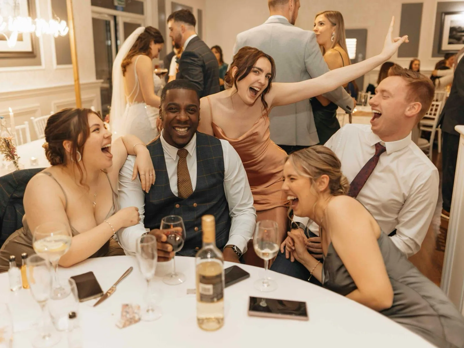 Table of friends laughing during the reception